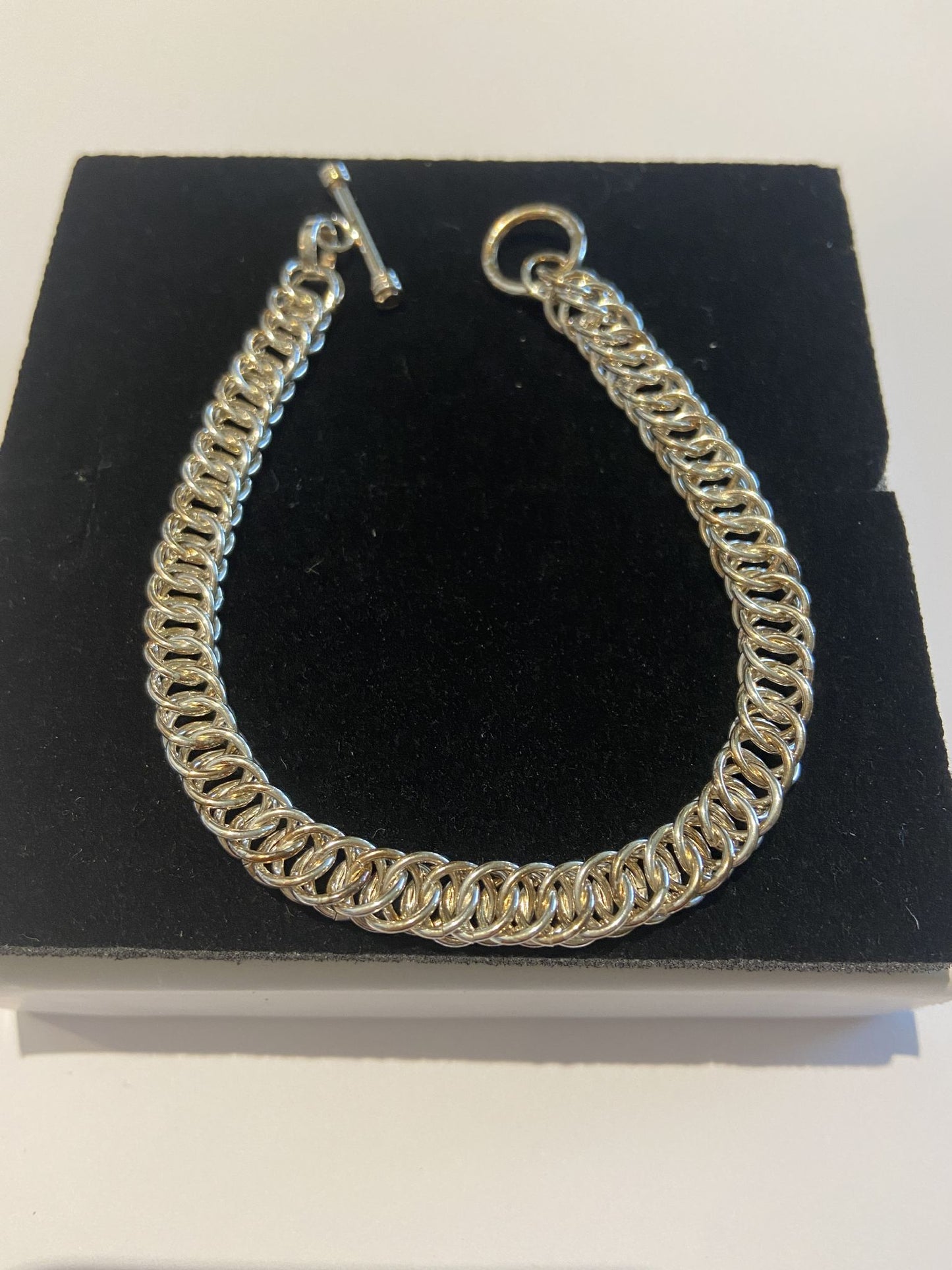 Silver Bracelet Cleverly entwined silver hoops knitted together to lie flat